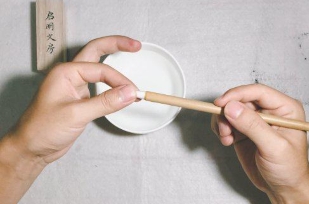 Take the brush out of the water and lightly twist the bristles to help them separate. This action also helps remove the glue on the surface of the bristles.