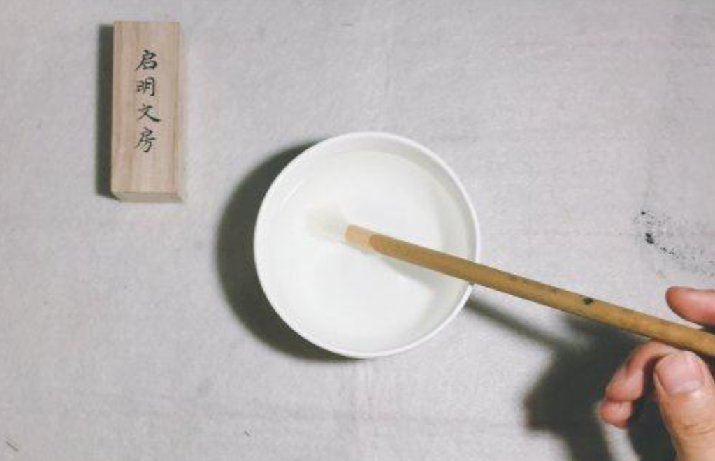 Place the brush back into the water, again applying gentle pressure to the brush tip against the bottom of the bowl.