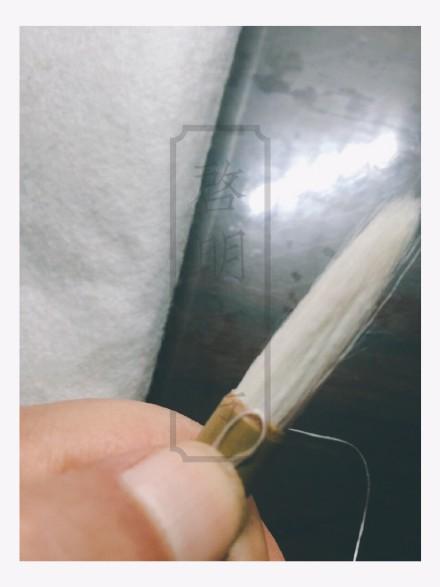 Hold down the thread end with your fingernail.